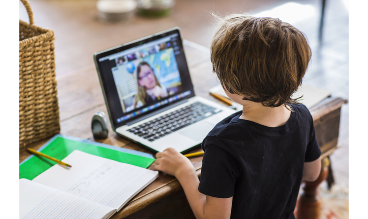 Six year old boy having a remote schooling session with his teacher