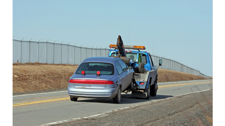 Tow Truck Towing A Vehicle On A Two Lane Highway