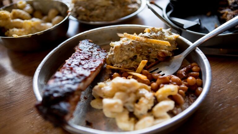 Variety of barbecue food with side dishes on table