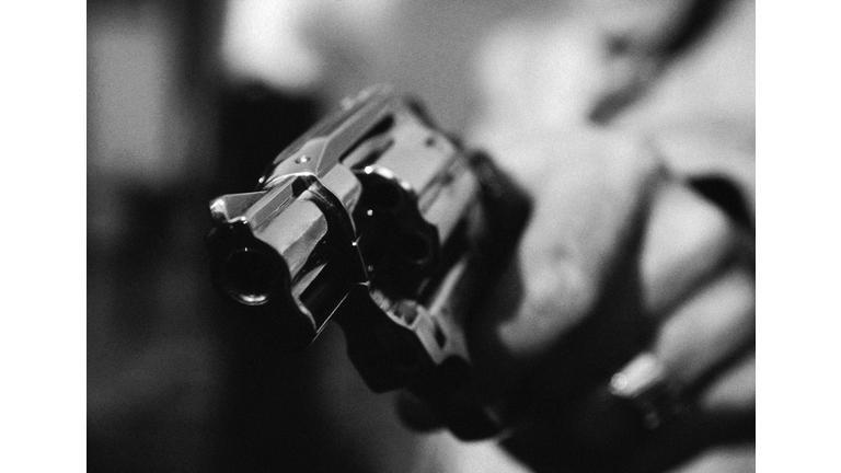 Hand holding gun, close-up, b&w