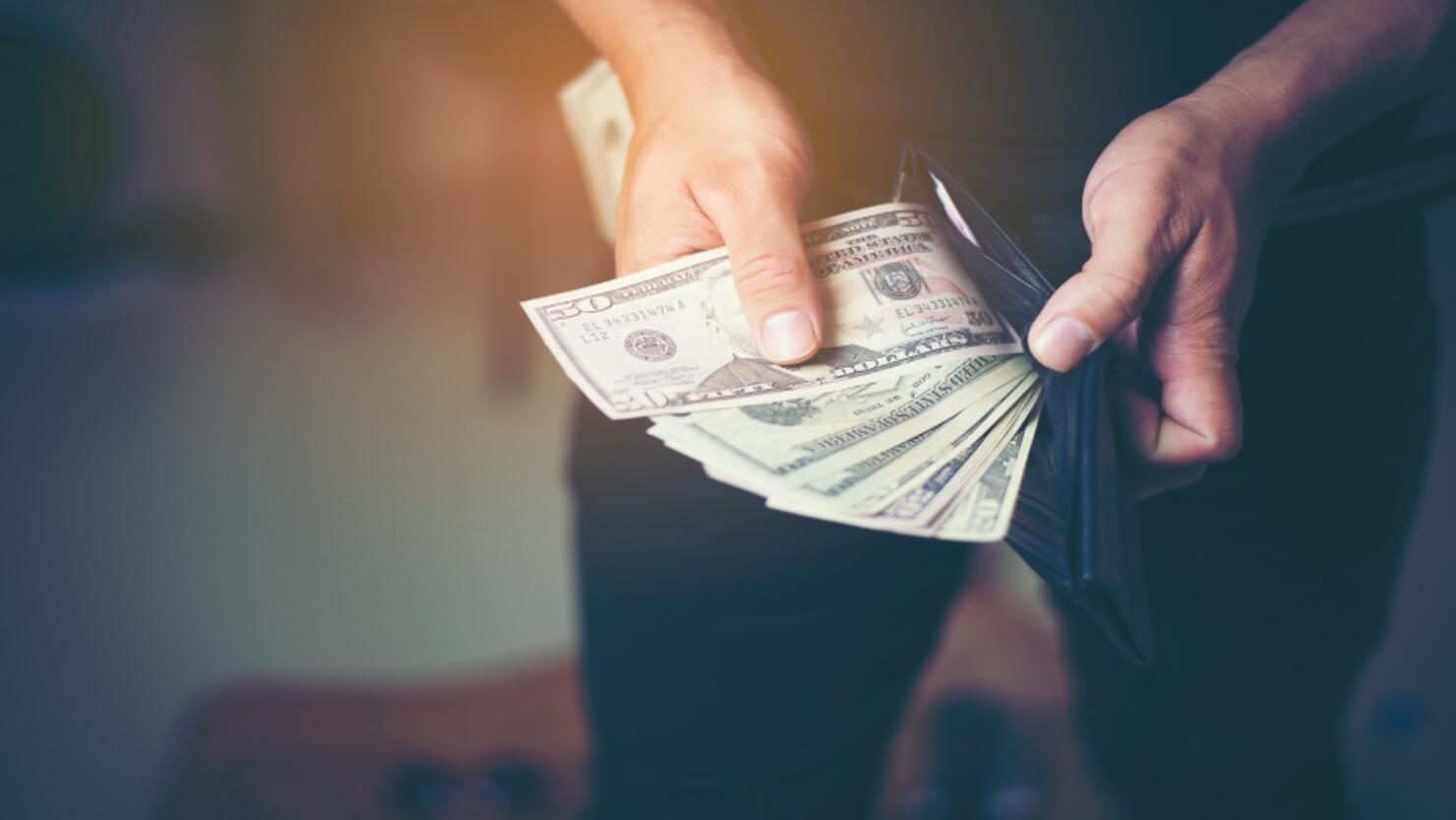 Close-Up Of Hand Removing Paper Currency From Wallet