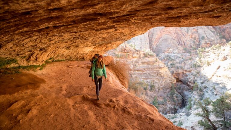 A mother and her son hiking a scenic trail through a cave