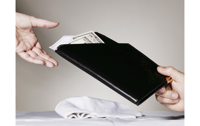 Person paying waiter for restaurant bill