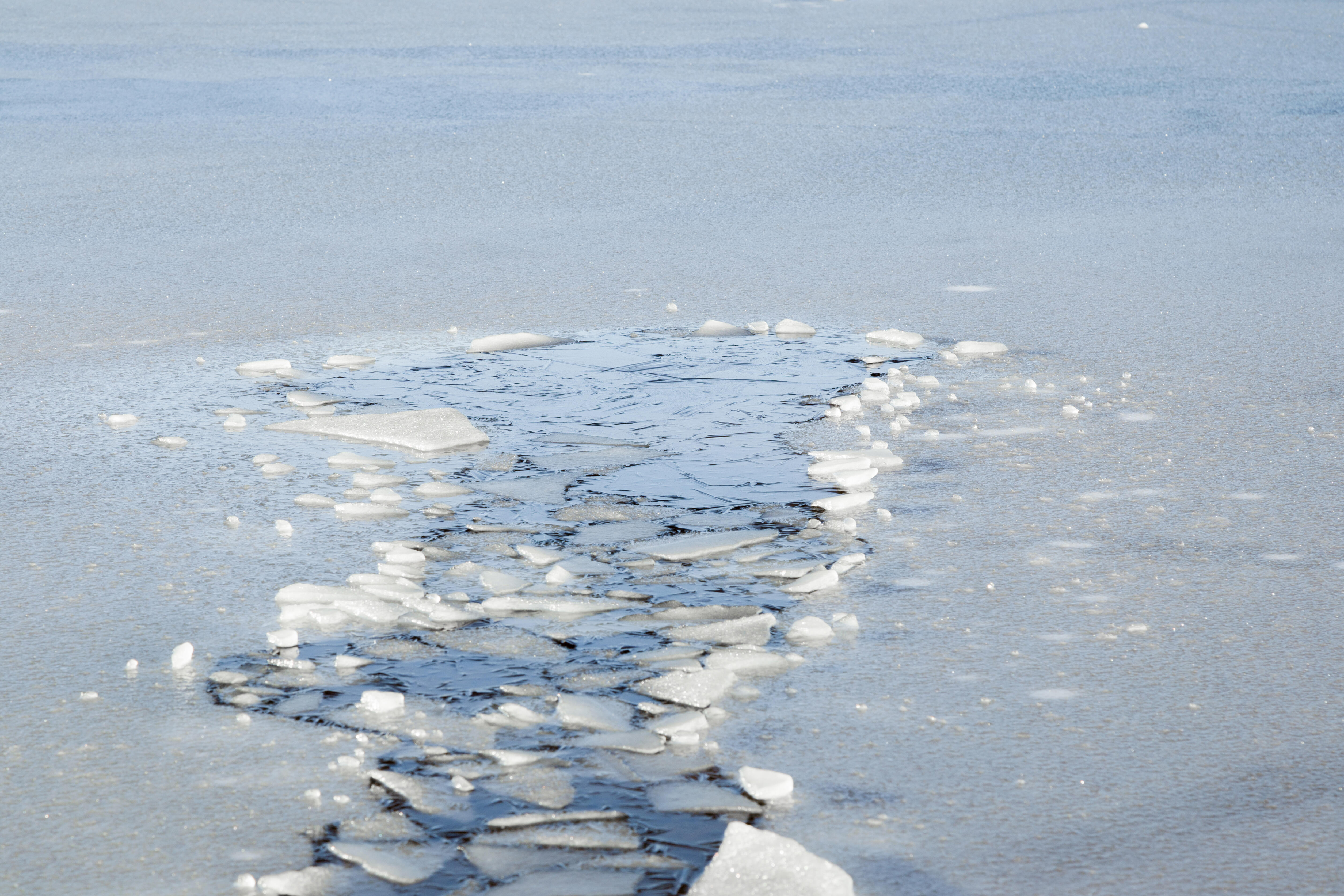 Вода едва блестела в реке. Лед на реке. Весенний лед. Полынья на льду. Лед на реке весной.