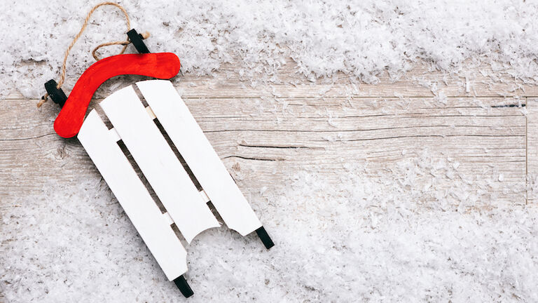 Close-Up Of Toy Sled And Snow On Table