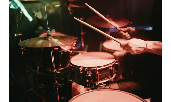 Drummer playing his drum kit on concert in club