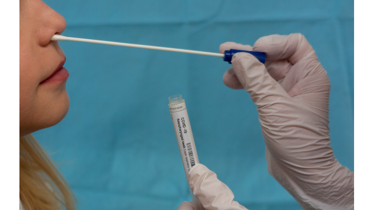 Doctor taking COVID-19 Nasopharyngeal swab from a blonde boy