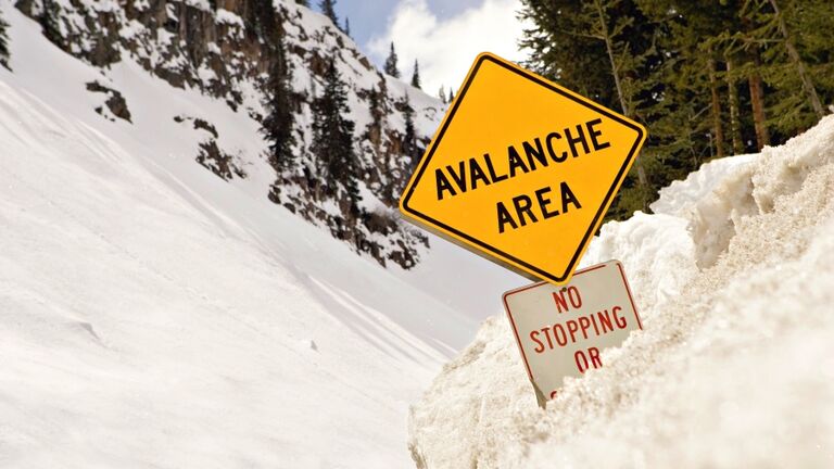 Avalanche area sign covered in snow