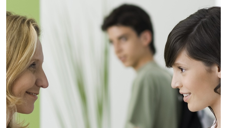 Concerned mother saying goodbye to teen daughter as she leaves for date with boyfriend