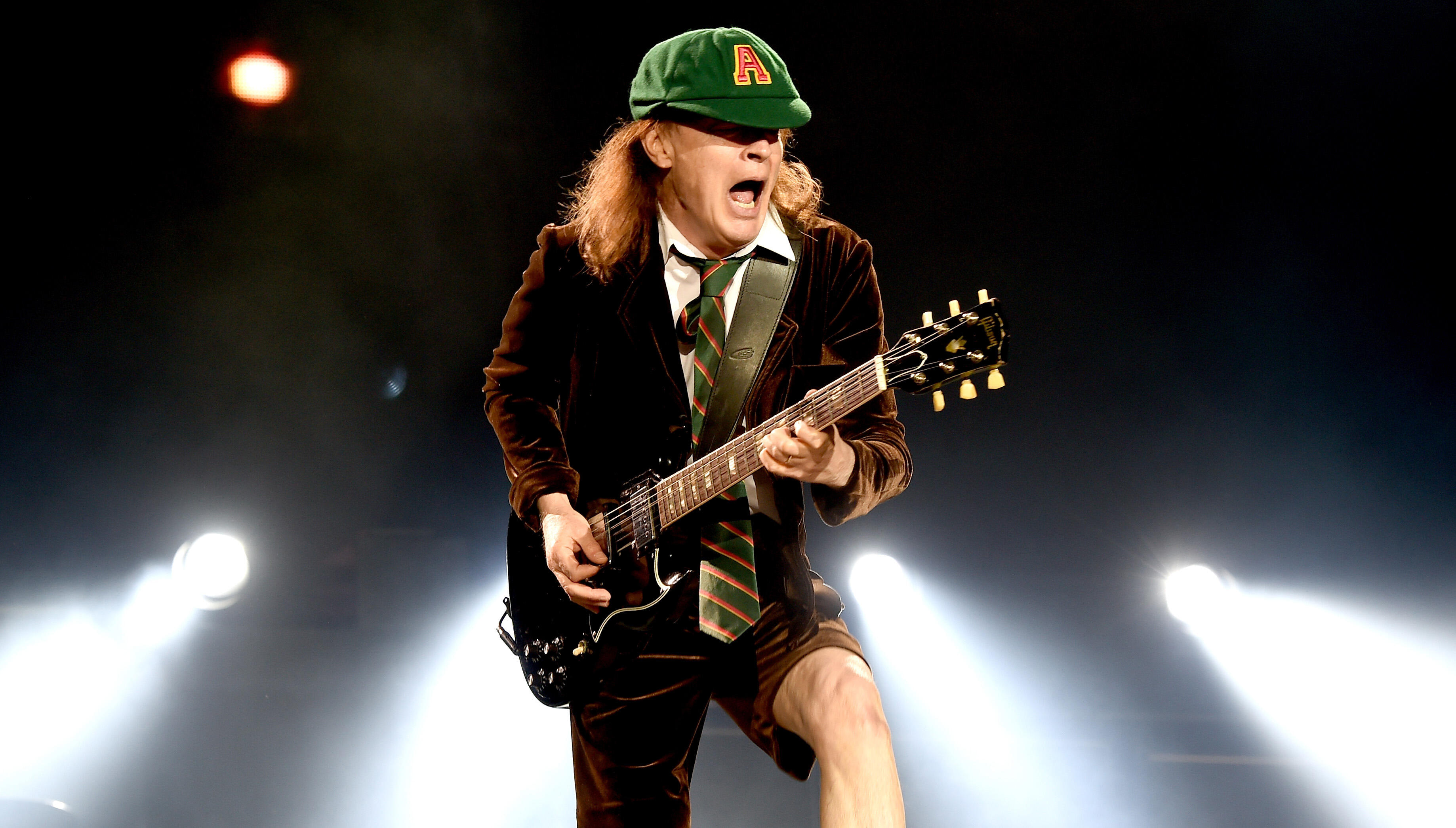 Группа acdc. Гитарист группы AC DC. Гитарист AC DC Ангус. AC DC Angus young молодой. AC DC Angus young 2021.