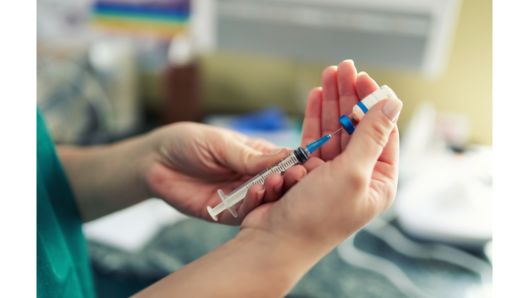 Doctor preparing the coronavirus COVID-19 vaccine. Details of hands and syringe.