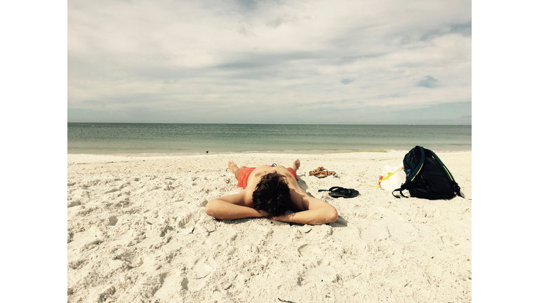 Man Is Sunbathing On The Beach