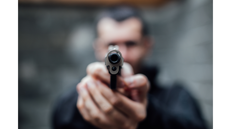 A man pointing a gun at lens