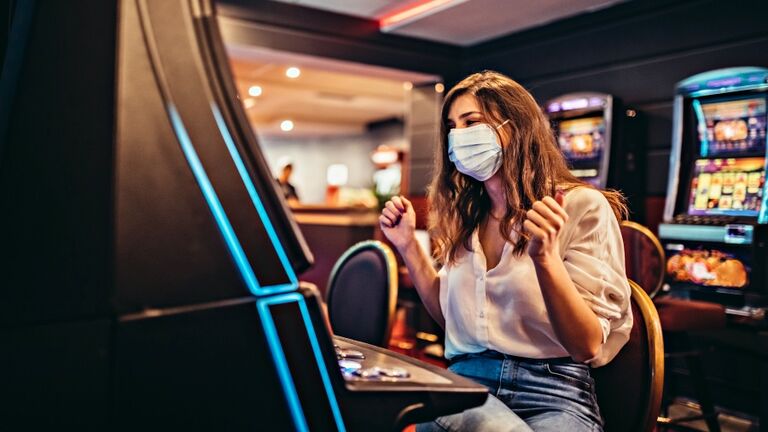 Woman playing slot machine in casino