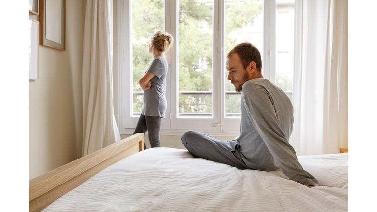 Mid adult couple in bedroom, having disagreement