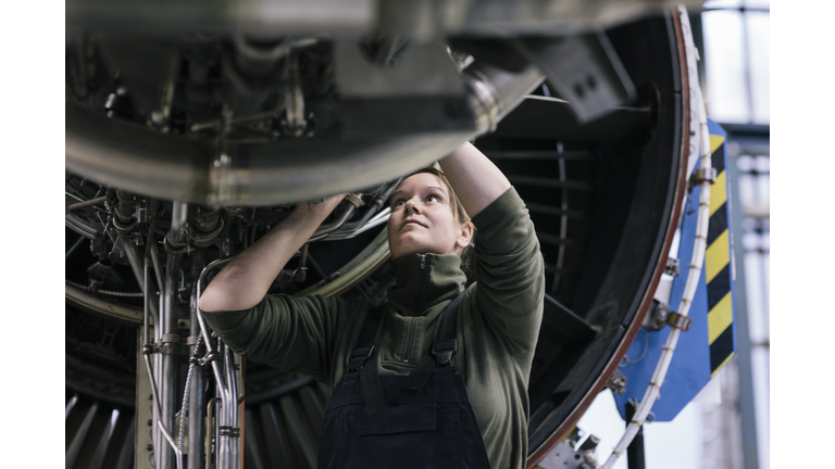 Female engineer working on jet engine