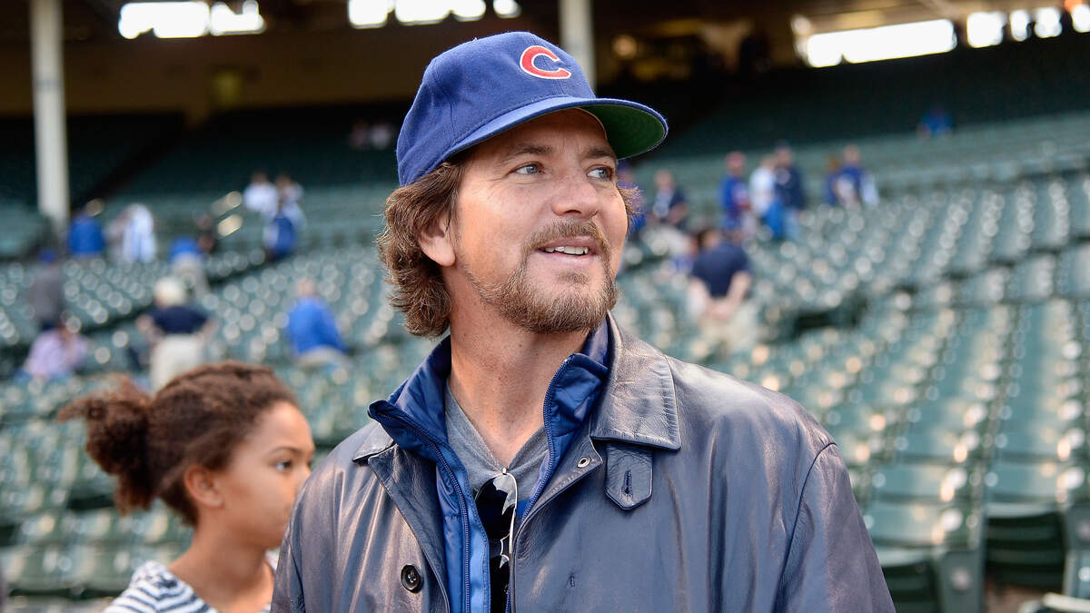 Pearl Jam frontman Eddie Vedder tries on a Chicago Cubs jersey as