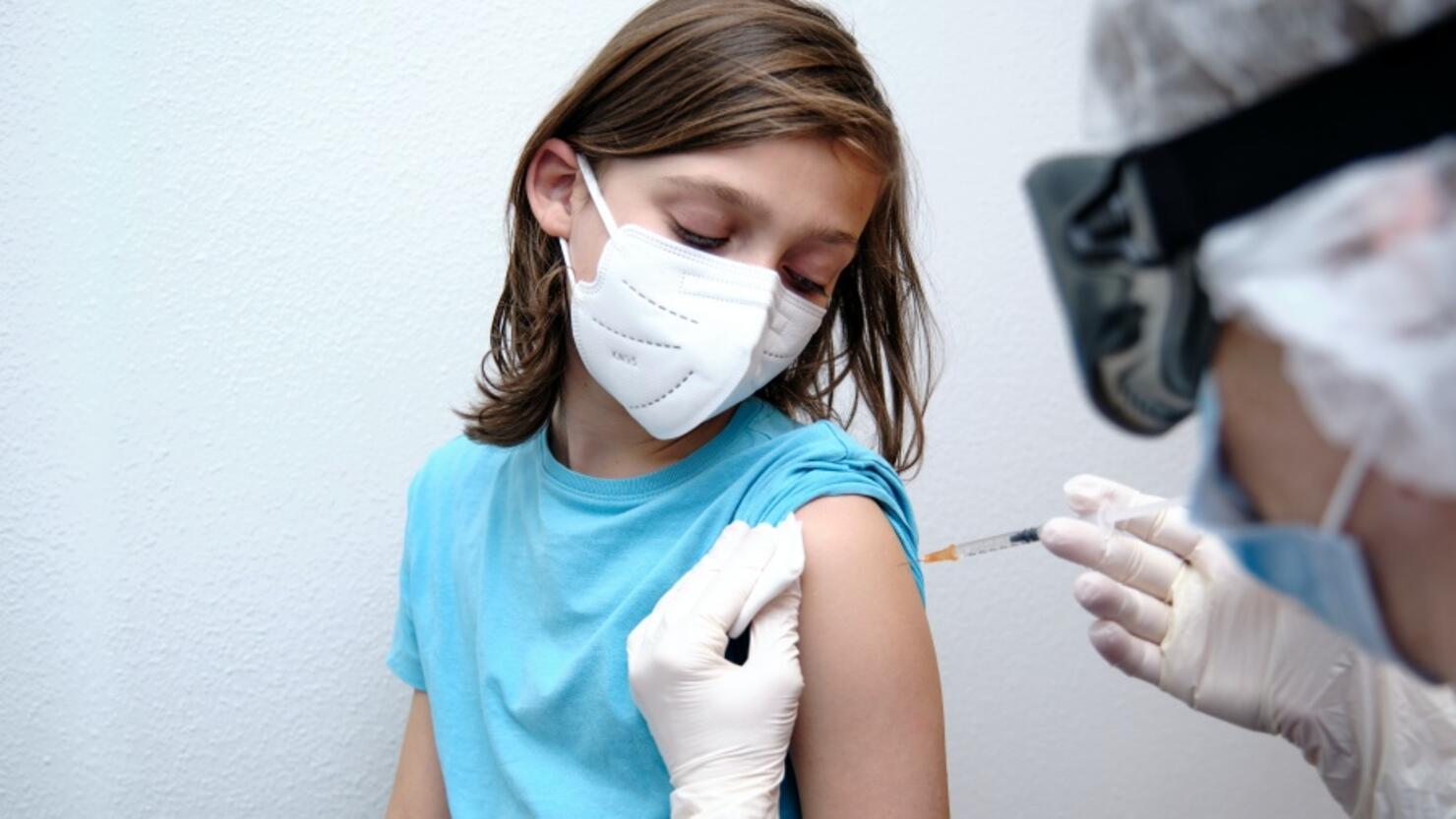 Female doctor giving covid-19 vaccine to a boy