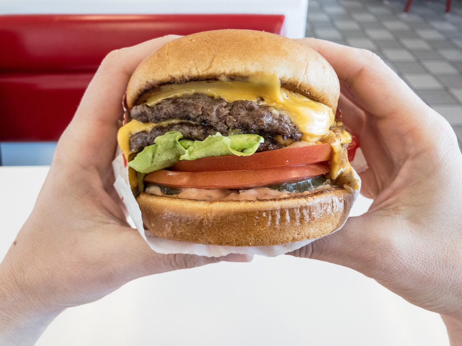 Close-Up Of Hand Holding Burger