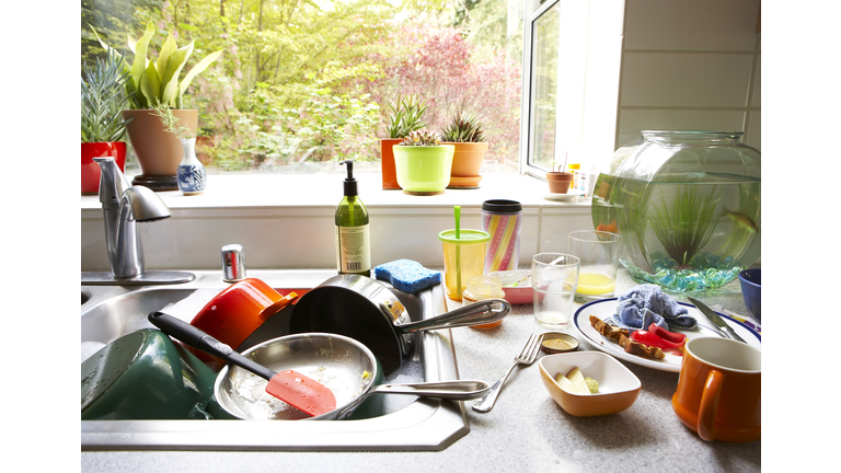 Dirty dishes piled in kitchen sink, close-up