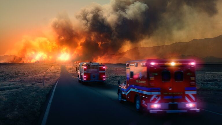 Ambulance driving to forest fire in desert