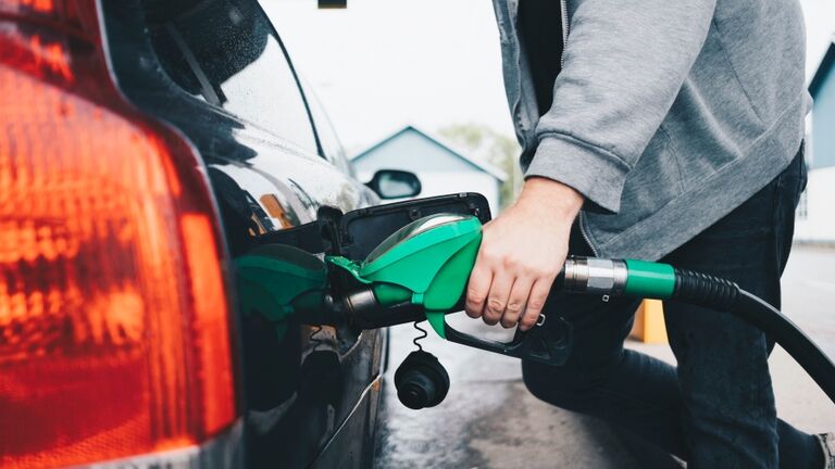 Midsection of man refueling car at gas station