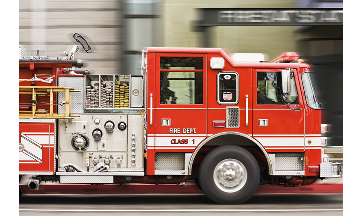 Blurred view of fire truck driving in city