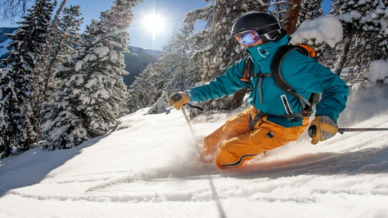 Skier skiing powder on a sunny day.