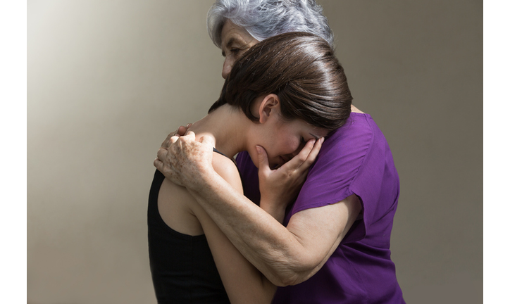 Crying granddaughter hugged by grandmother