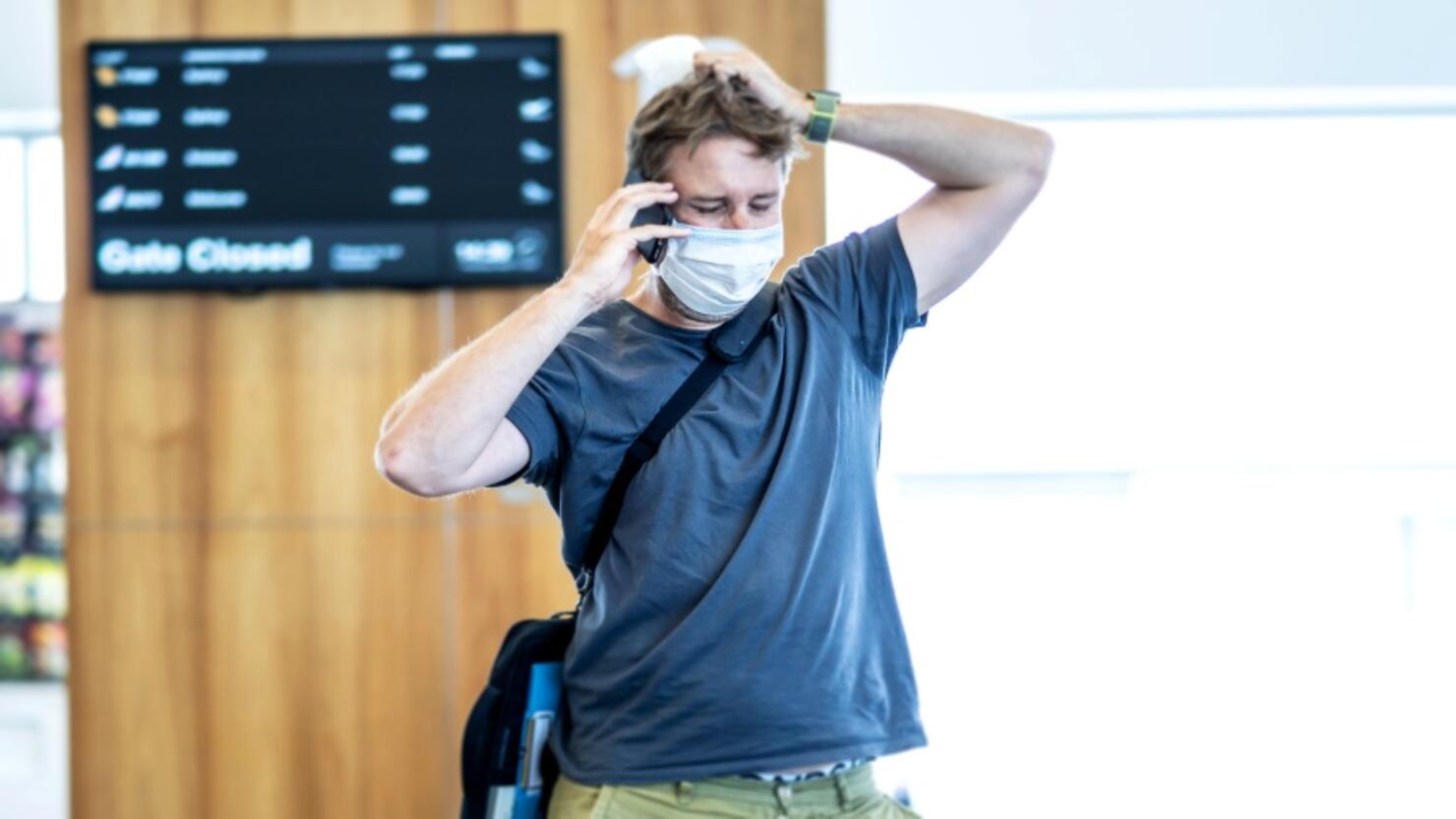 COVID-19 worldwide borders closures.Traveler with face mask stuck in airport terminal after being denied entry to other countries. Passenger stranded in airport on his travel back to home country.