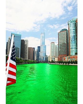 Chicago River near Trump Tower and american flag, which is dyed green for St. Patrick`s day, as crowds surround scene.