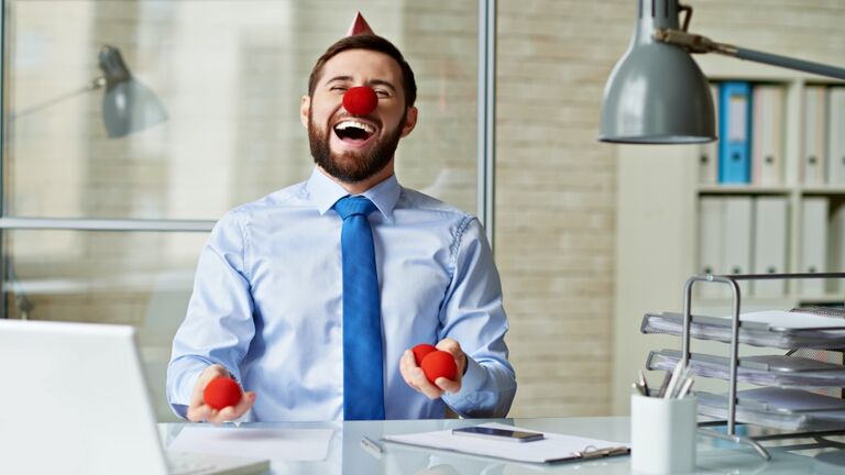 Excited businessman laughing in office