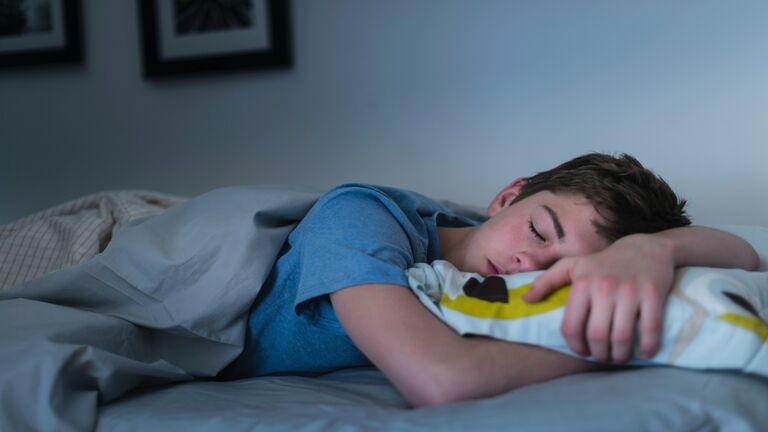 USA, New Jersey, Jersey City, Teenage boy (16-17) sleeping in bed