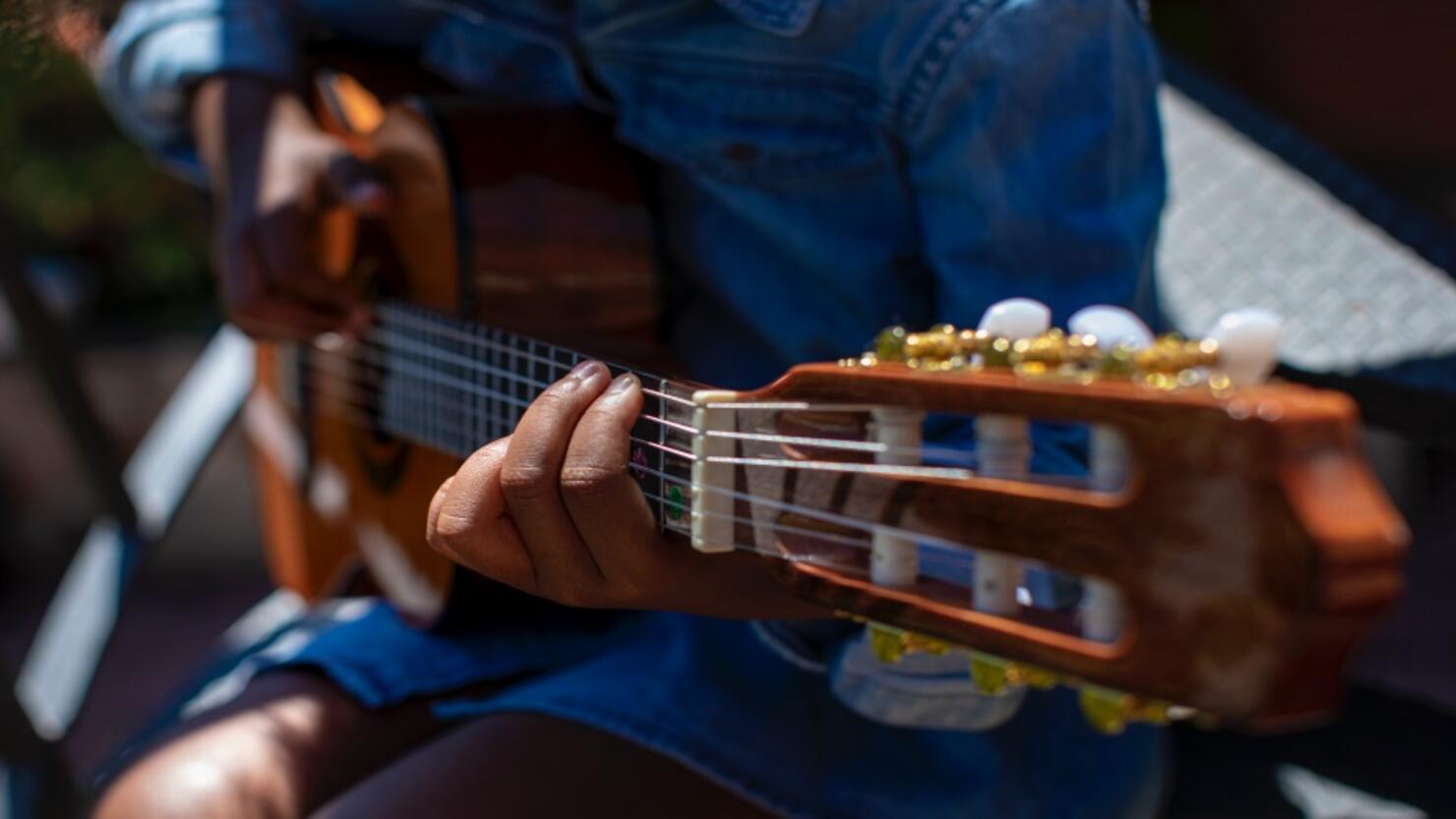 small girl learning to play the guitar