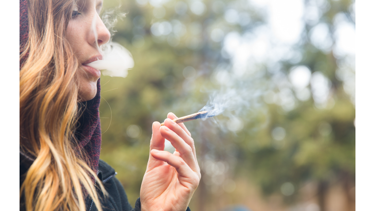 Portrait Of Woman Smoking Marijuana Joint Outdoors