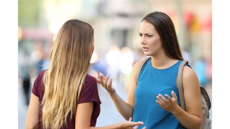 Two friends talking seriously on the street