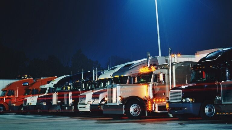 Semi-trucks in parking lot at night