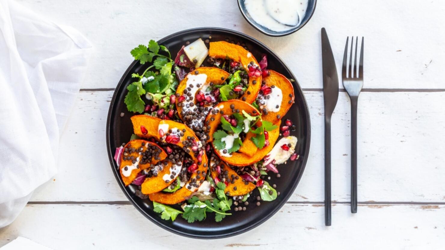 Autumnal salad with fried pumpkin, lentils, radicchio, pomegranate seeds, leaf salad and parsley with dressing