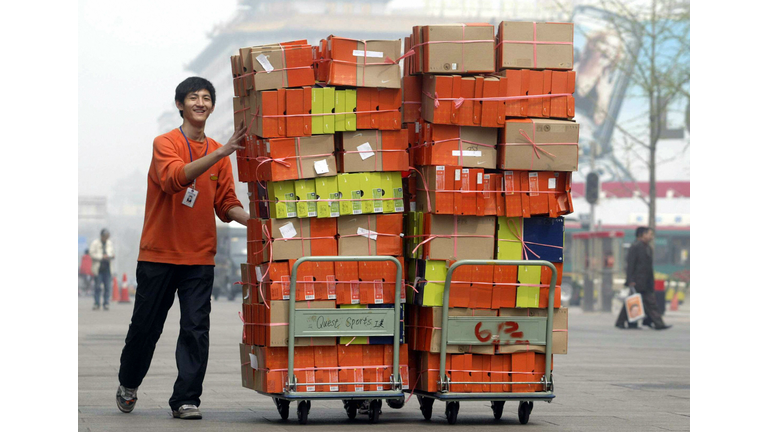 A store employee pushes carts loaded wit