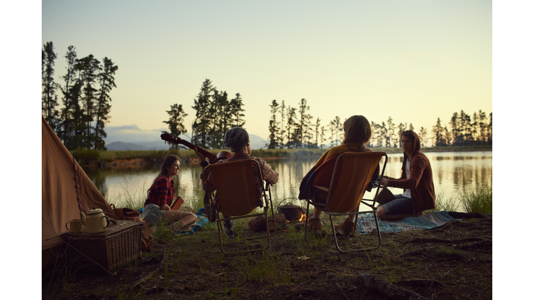 Young friends camping by lake