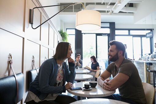 Couple drinking coffee and talking in cafe