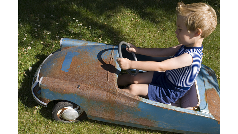 Boy in an old toy car
