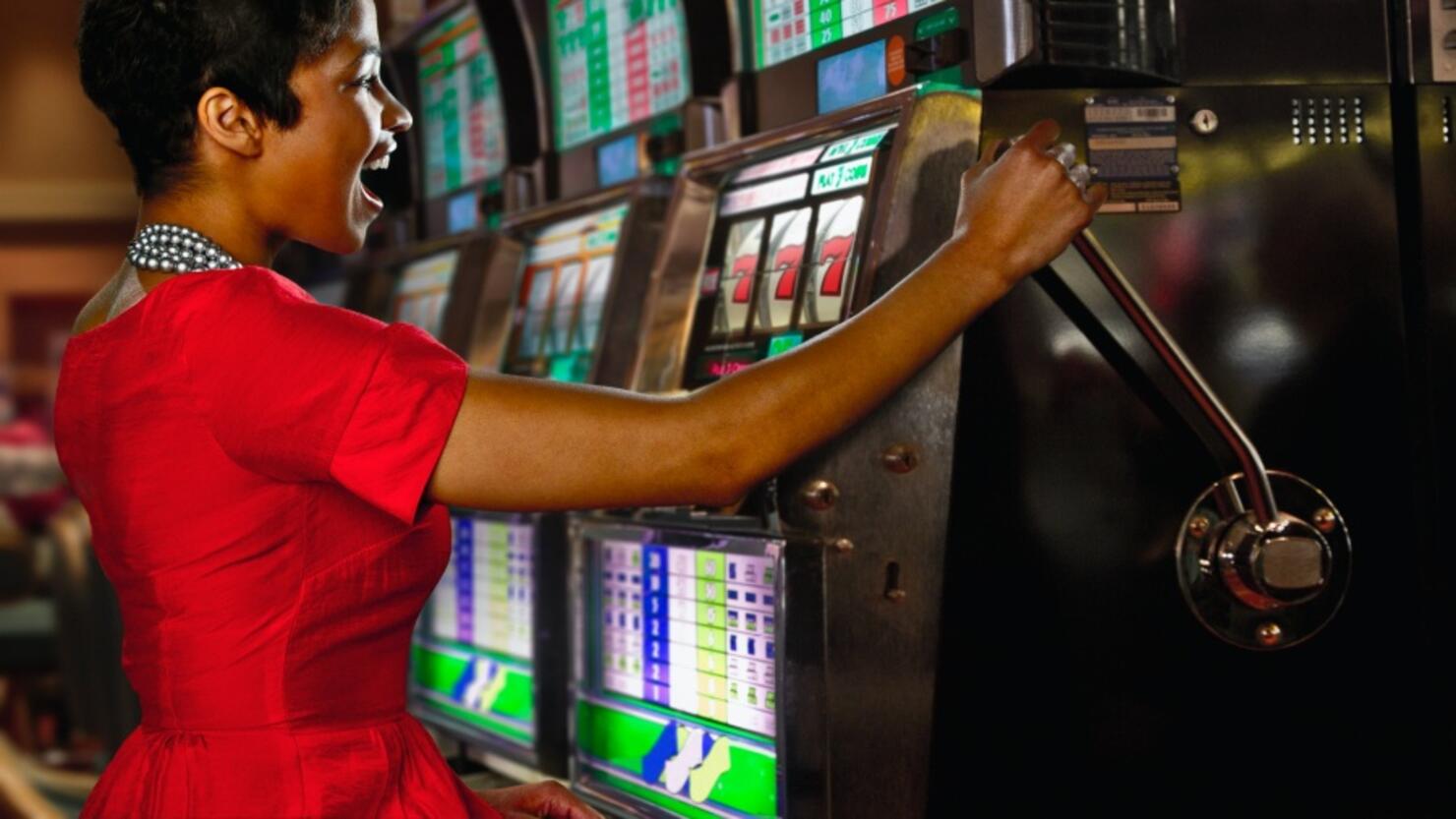 Mixed race woman playing slot machines in casino