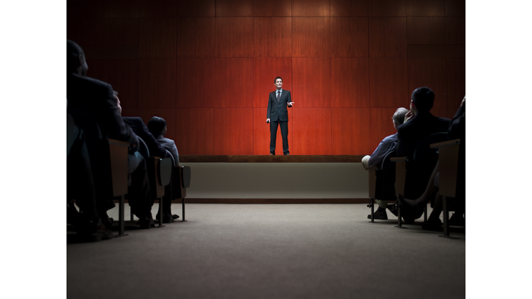 Business man making speech in front of crowd