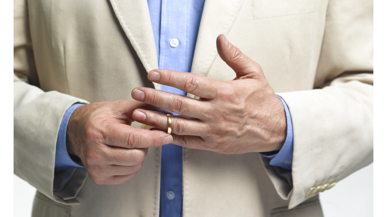 Divorced man taking off wedding ring