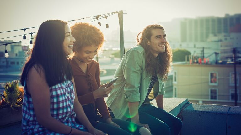 Friends sharing a laugh on urban rooftop