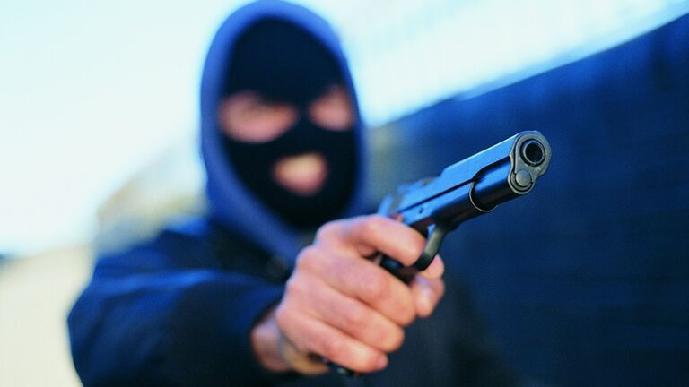 Male Criminal Wearing a Baraclava and Aiming a Gun