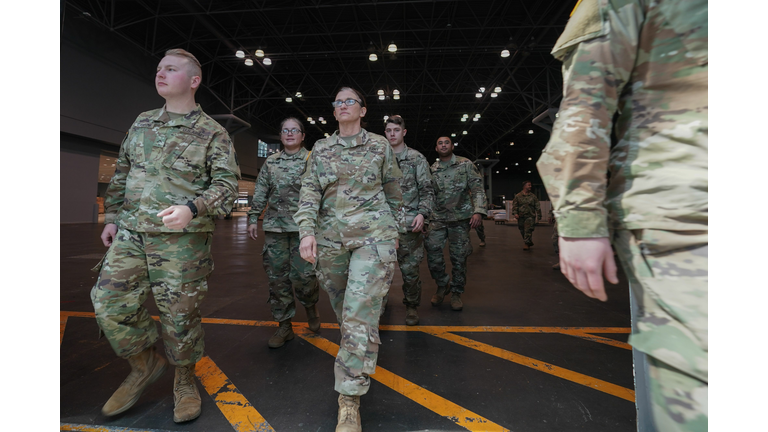 Members of the Army National Guard walk through the Javits Center to help construct a 1,000-bed facility at the center. 