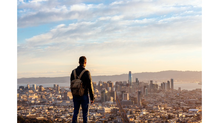 Man overlooking San Francisco skyline from above during sunrise, San Francisco, California, USA