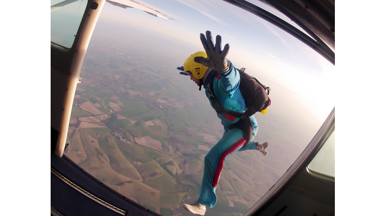 Parachutist jumps through the door of the plane